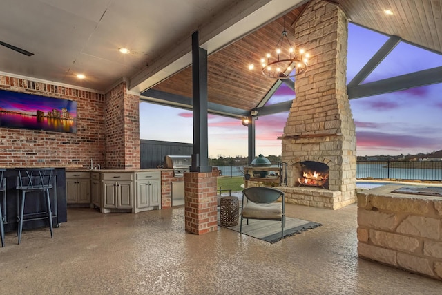 view of patio / terrace with an outdoor stone fireplace and area for grilling