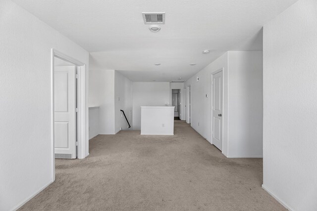 spare room featuring light carpet and visible vents