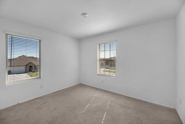 carpeted spare room featuring baseboards