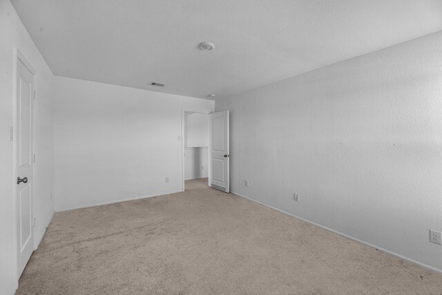 unfurnished bedroom with light carpet and visible vents