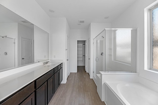 full bathroom featuring a bath, a wealth of natural light, a stall shower, and visible vents