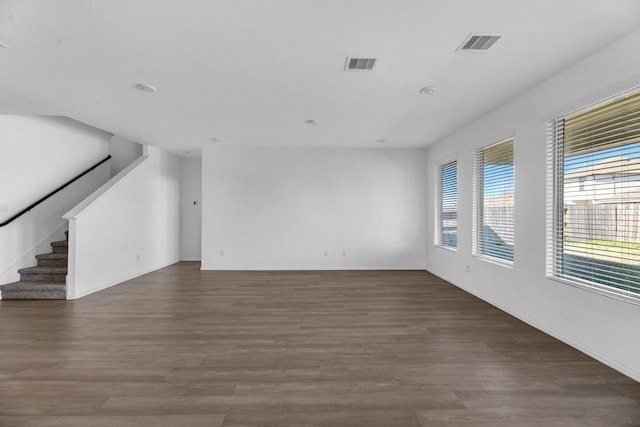 spare room with stairway, visible vents, and wood finished floors