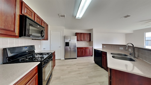 kitchen with black appliances, visible vents, light countertops, and a sink