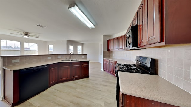 kitchen featuring a sink, visible vents, black dishwasher, light countertops, and gas stove