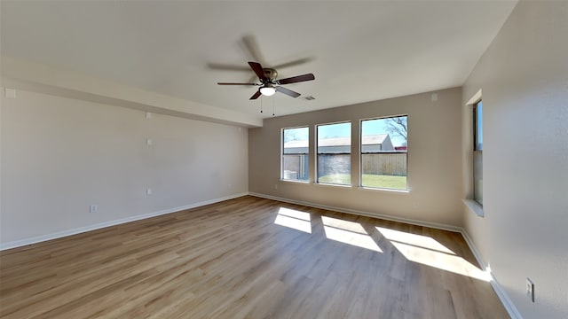 spare room featuring visible vents, ceiling fan, light wood-style flooring, and baseboards