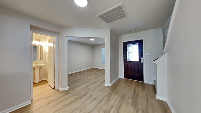 entrance foyer with light wood finished floors, visible vents, and baseboards