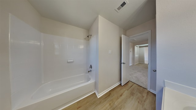 full bathroom featuring visible vents, bathing tub / shower combination, baseboards, and wood finished floors