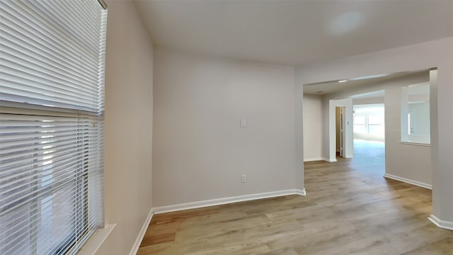 empty room with light wood-type flooring and baseboards