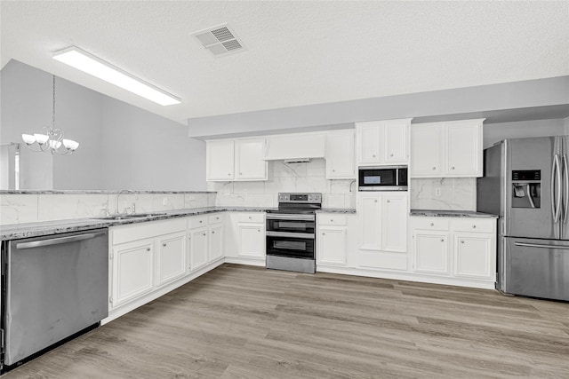 kitchen featuring visible vents, a sink, white cabinetry, stainless steel appliances, and light wood-style floors