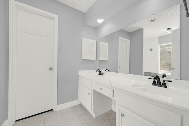 full bath with tile patterned flooring, visible vents, a textured ceiling, and a sink