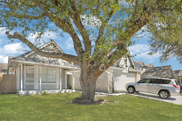 view of front of house with a front lawn, concrete driveway, fence, and an attached garage