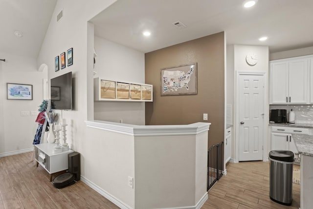 hallway featuring light wood-style flooring, visible vents, baseboards, and recessed lighting