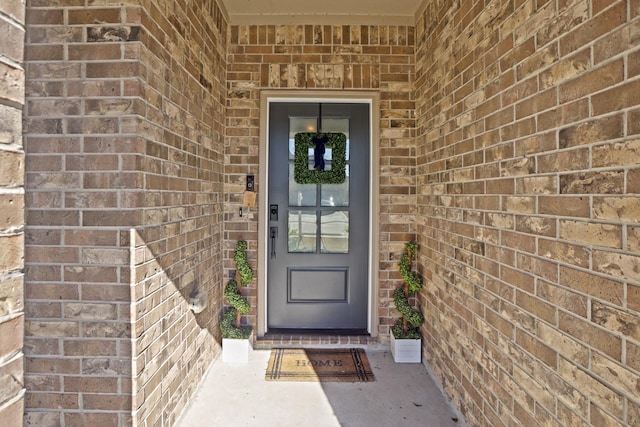 doorway to property with brick siding