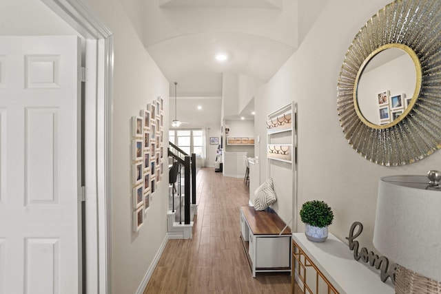 corridor with recessed lighting, stairway, baseboards, and wood finished floors