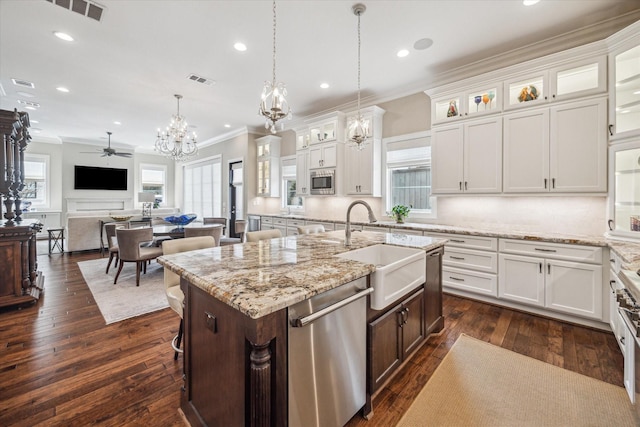 kitchen featuring crown molding, visible vents, appliances with stainless steel finishes, white cabinets, and a sink