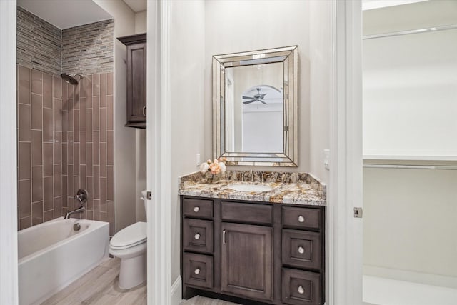 full bathroom with washtub / shower combination, vanity, toilet, and wood finished floors