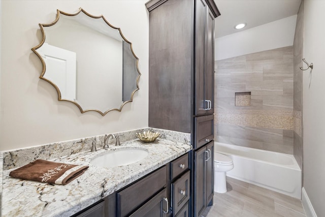 bathroom featuring toilet, shower / bathing tub combination, and vanity