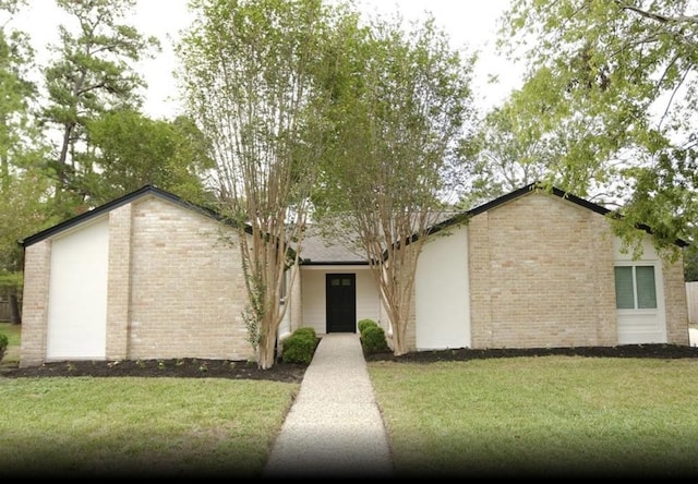 view of front of home featuring brick siding and a front lawn