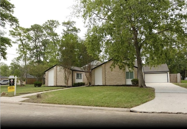 view of front of house with a garage, a front yard, concrete driveway, and brick siding