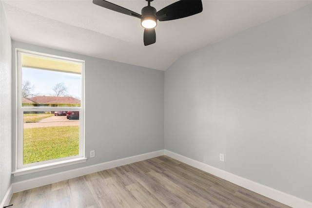 spare room with a healthy amount of sunlight, baseboards, and wood finished floors