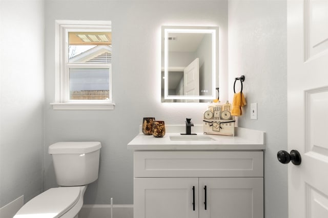 bathroom featuring vanity, toilet, and baseboards