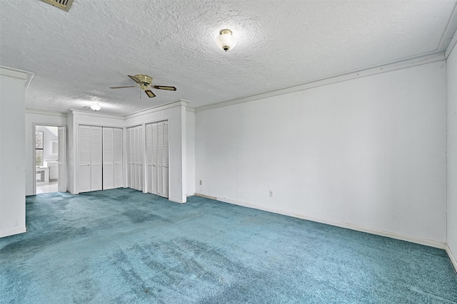 spare room featuring baseboards, ceiling fan, a textured ceiling, crown molding, and carpet floors