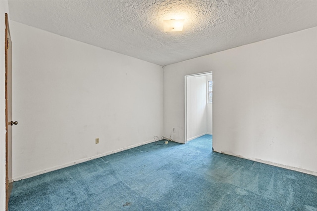 empty room with a textured ceiling and carpet