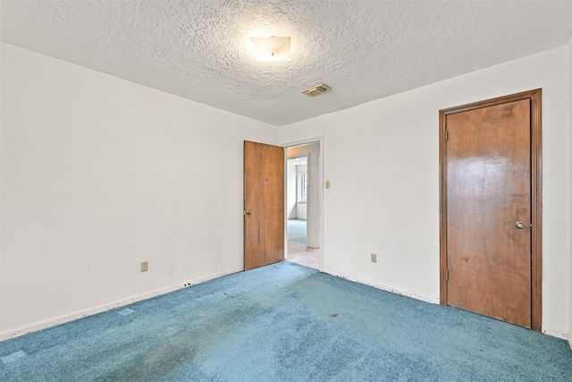 unfurnished room featuring carpet and a textured ceiling