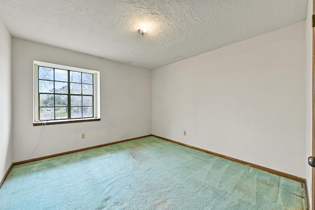 unfurnished room featuring a textured ceiling, carpet floors, and baseboards