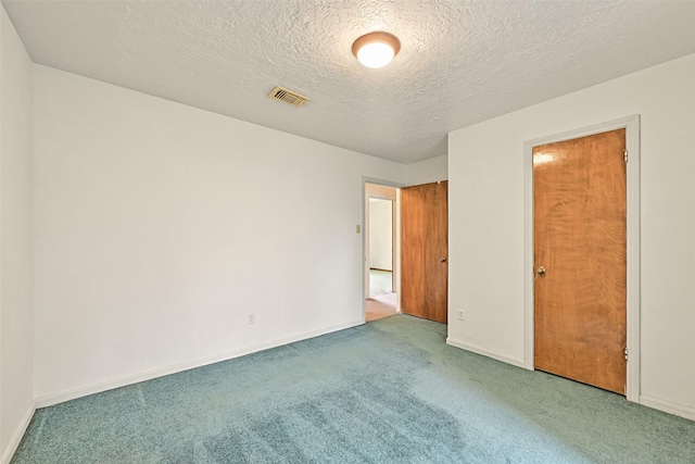 unfurnished bedroom featuring carpet, visible vents, a textured ceiling, and baseboards