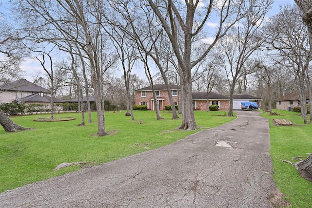 view of front of home featuring a garage, a front lawn, and brick siding