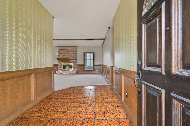 interior space with wainscoting, visible vents, and a brick fireplace