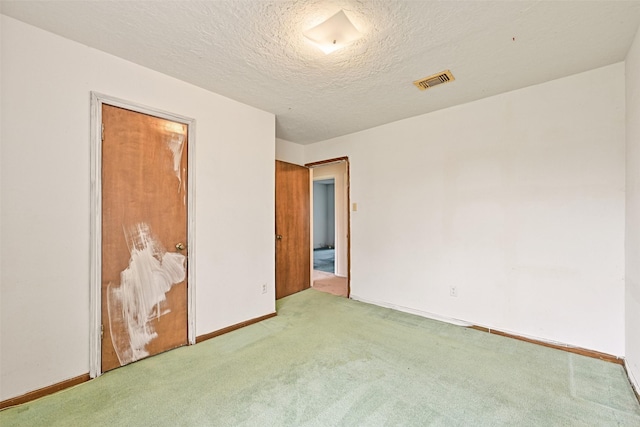 unfurnished bedroom with baseboards, a textured ceiling, visible vents, and carpet flooring