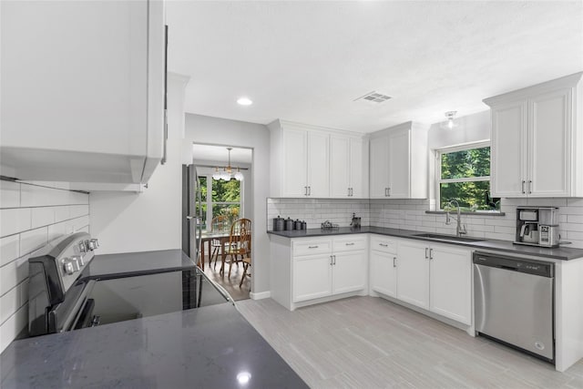 kitchen with visible vents, range with electric cooktop, backsplash, stainless steel dishwasher, and a sink