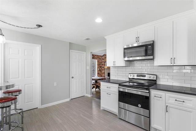 kitchen with stainless steel appliances, dark countertops, and tasteful backsplash