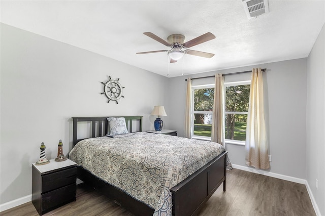 bedroom with visible vents, ceiling fan, baseboards, and wood finished floors