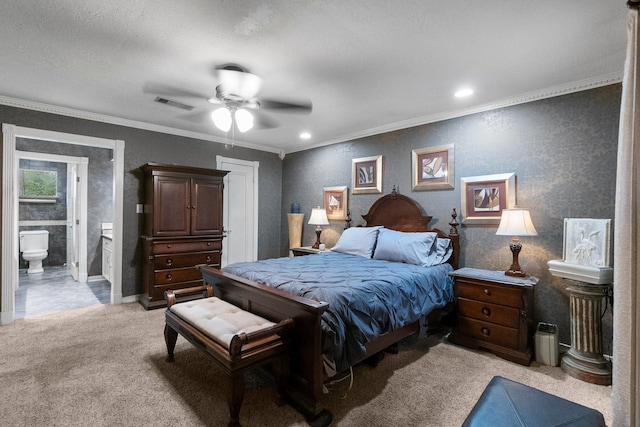 bedroom featuring crown molding, light colored carpet, visible vents, ensuite bathroom, and a ceiling fan