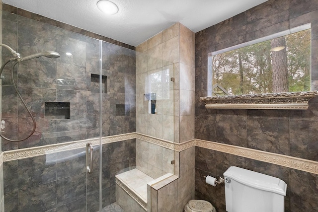 full bathroom featuring a shower stall, toilet, and tile walls