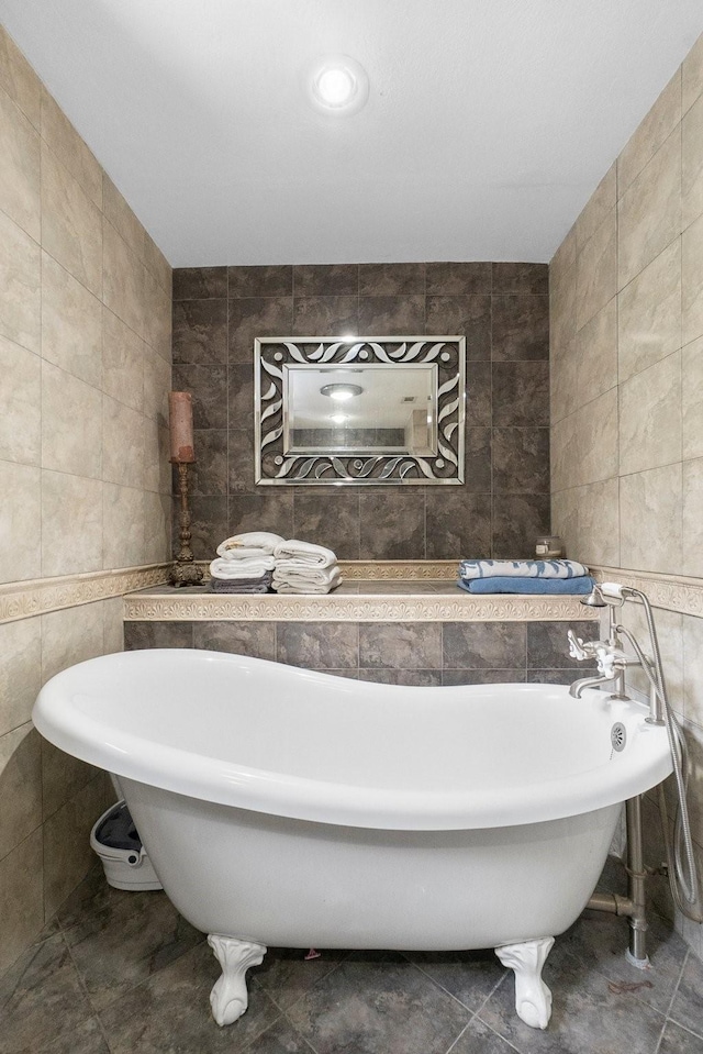 full bathroom with tile patterned flooring, a freestanding bath, and tile walls