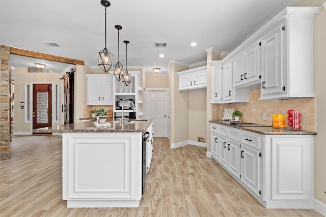 kitchen with visible vents, white cabinets, and a sink