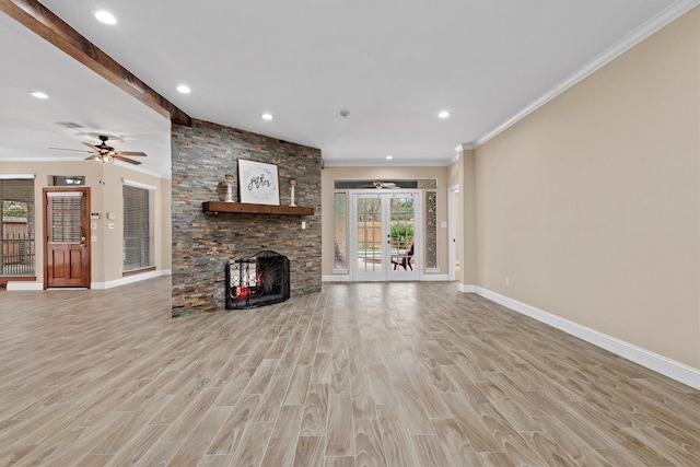 unfurnished living room featuring baseboards, wood finished floors, crown molding, french doors, and a fireplace