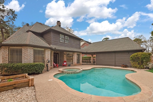 view of swimming pool with a patio area, a garden, and a pool with connected hot tub