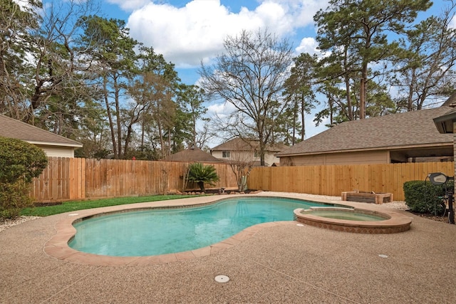 view of swimming pool featuring a pool with connected hot tub and a fenced backyard