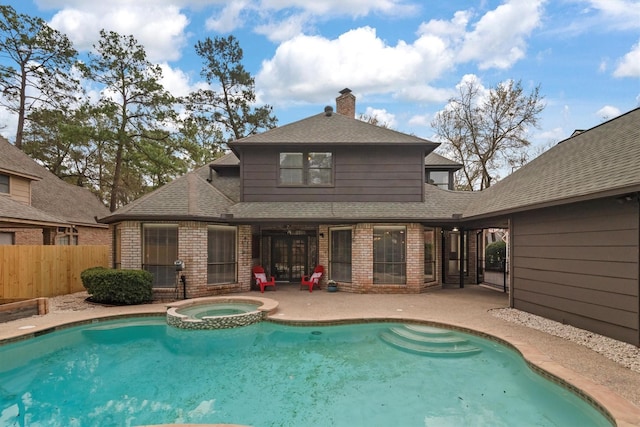 rear view of house featuring brick siding, a shingled roof, fence, and a patio