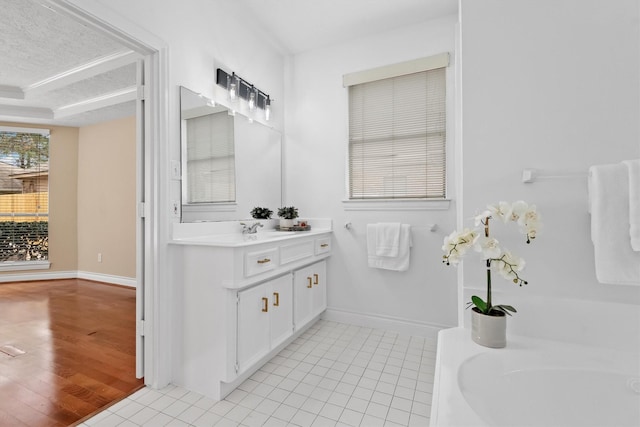 bathroom with tile patterned flooring, baseboards, a textured ceiling, and vanity