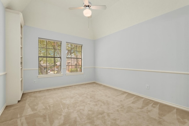 spare room with lofted ceiling, carpet floors, a ceiling fan, and baseboards