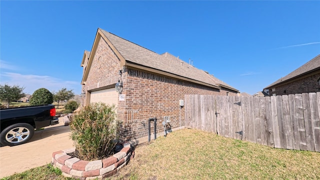 view of property exterior with an attached garage, fence, a lawn, and brick siding