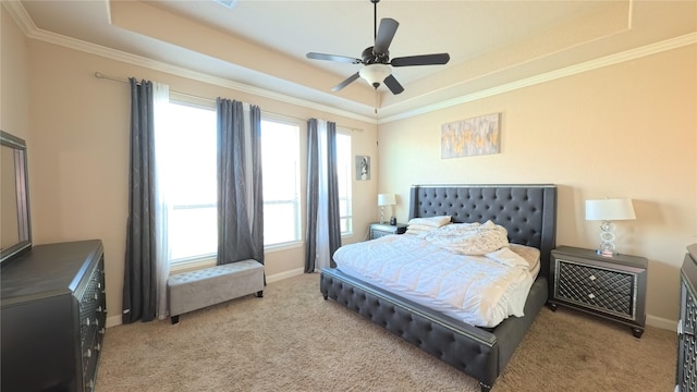 bedroom featuring ornamental molding, a tray ceiling, carpet, and baseboards