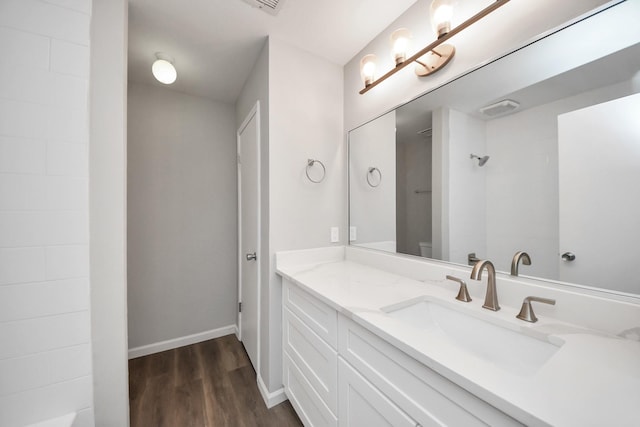 full bathroom featuring vanity, wood finished floors, and baseboards