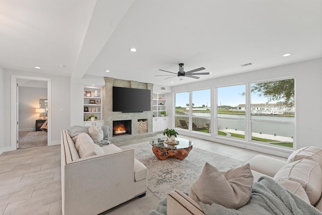 living room with built in features, recessed lighting, a fireplace, and baseboards